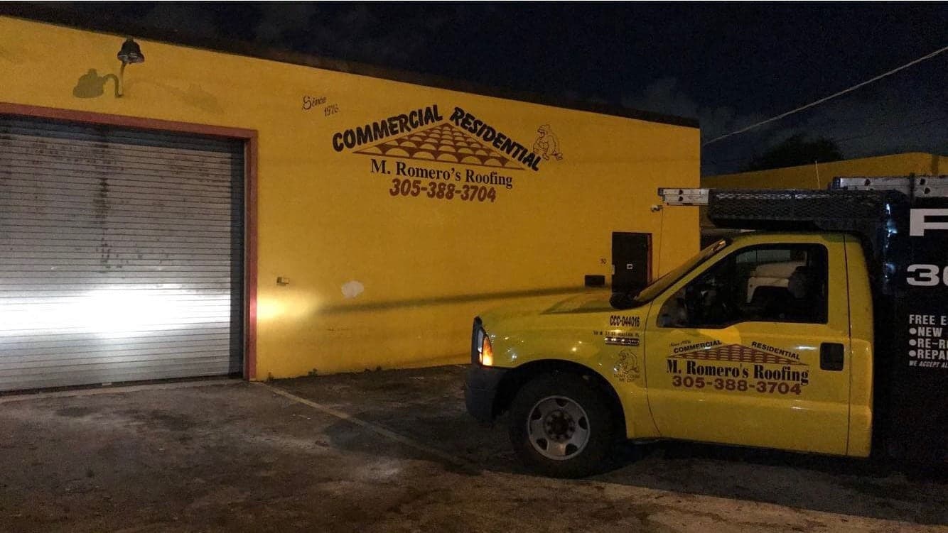 The Hialeah shop after dark, with a truck parked out front.