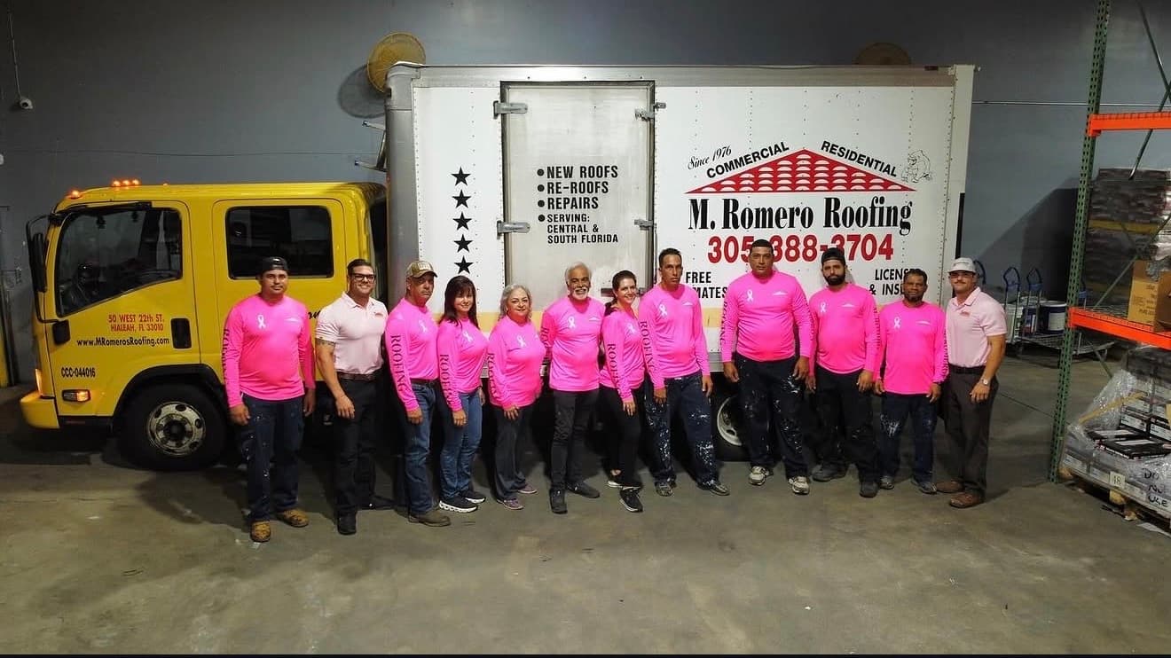The M. Romero's Roofing team in front of one of our company trucks.